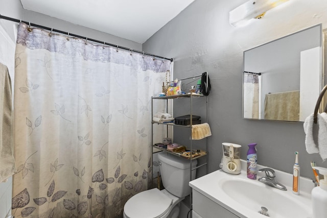 bathroom featuring vanity, toilet, and walk in shower