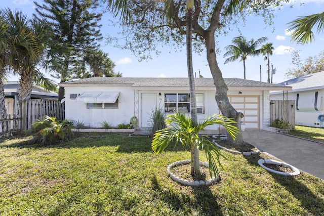 ranch-style house featuring a garage and a front lawn