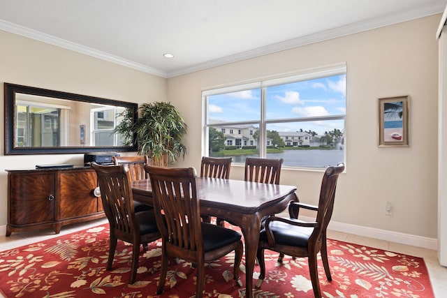 dining space featuring ornamental molding, a water view, and tile patterned floors