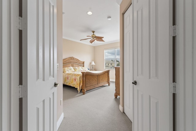 carpeted bedroom featuring crown molding and ceiling fan