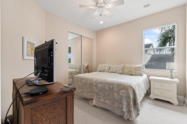 carpeted bedroom with ceiling fan and a closet