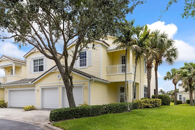 view of front of home with a balcony, a front lawn, and a garage