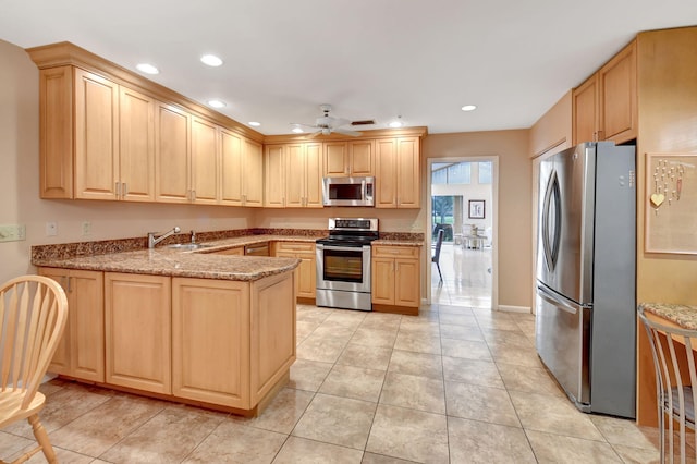 kitchen featuring ceiling fan, appliances with stainless steel finishes, and light brown cabinets