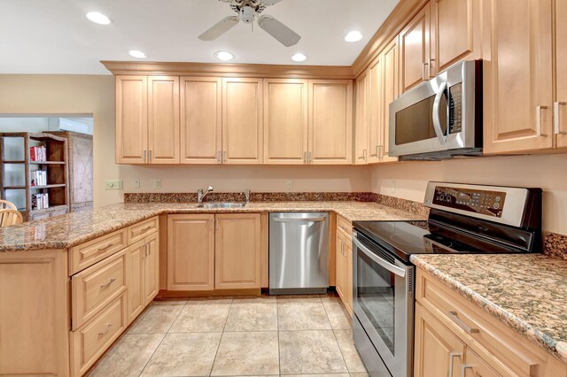 kitchen featuring decorative light fixtures, ceiling fan, kitchen peninsula, sink, and stainless steel appliances