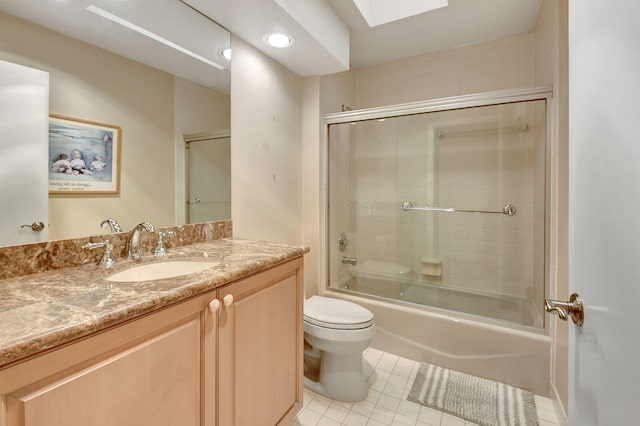 full bathroom with combined bath / shower with glass door, vanity, toilet, and tile patterned flooring