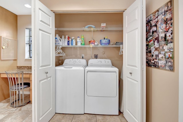 clothes washing area featuring light tile patterned floors and washing machine and clothes dryer