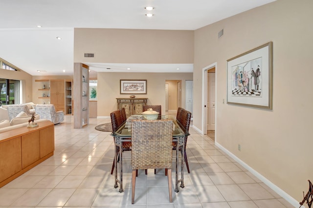 tiled dining room featuring lofted ceiling and a healthy amount of sunlight