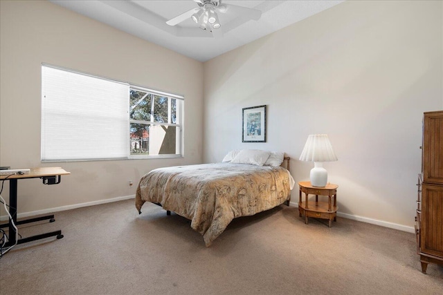 bedroom featuring ceiling fan, a raised ceiling, and carpet floors