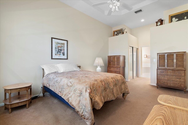 bedroom with ensuite bath, ceiling fan, and light colored carpet