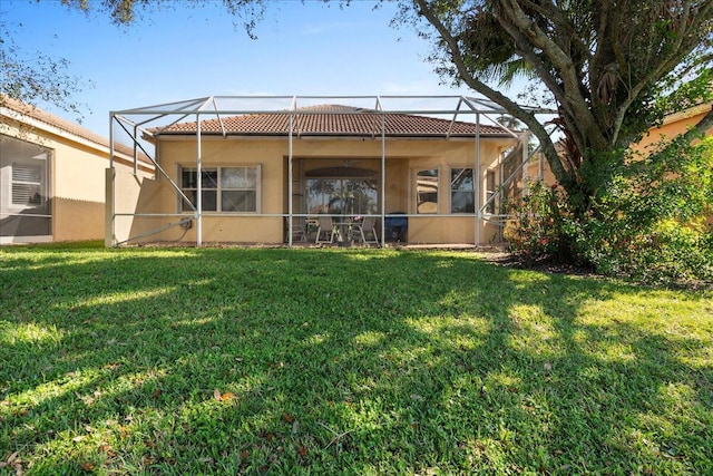 rear view of property with a lanai and a yard