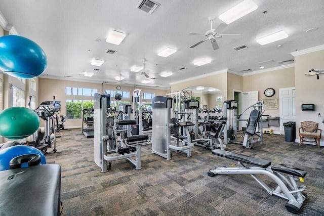 workout area with ceiling fan, crown molding, and a textured ceiling