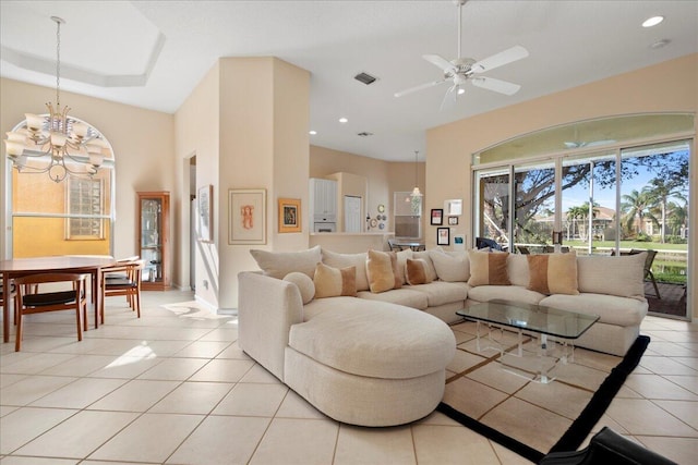 living room featuring light tile patterned floors and ceiling fan with notable chandelier