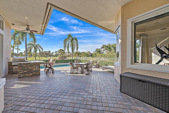 view of patio / terrace featuring a fenced in pool, ceiling fan, a grill, area for grilling, and exterior bar