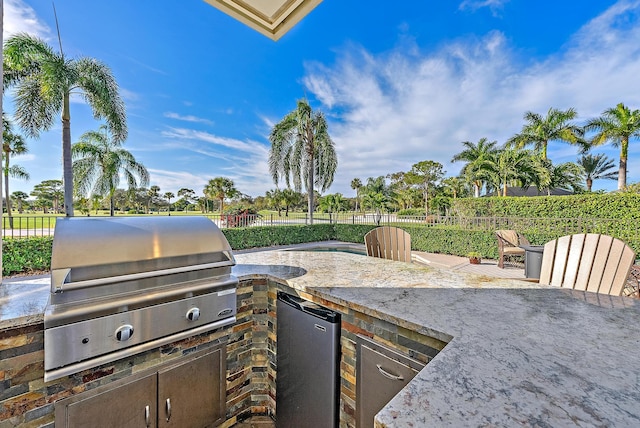 view of patio with an outdoor kitchen and a grill