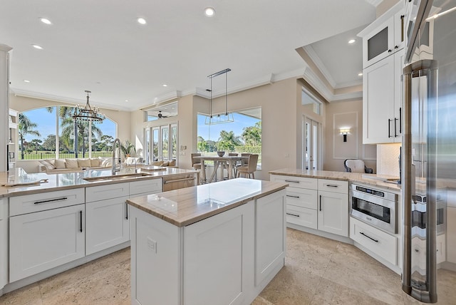 kitchen featuring pendant lighting, sink, white cabinetry, a kitchen island, and oven