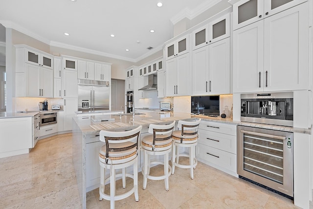 kitchen with white cabinetry, light stone countertops, beverage cooler, and stainless steel built in fridge