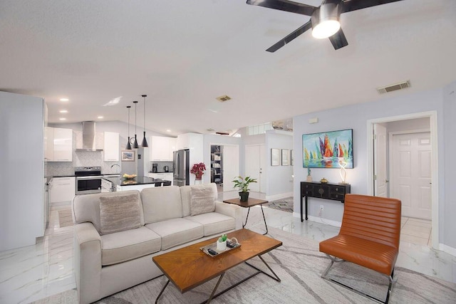 living room with ceiling fan, lofted ceiling, and sink