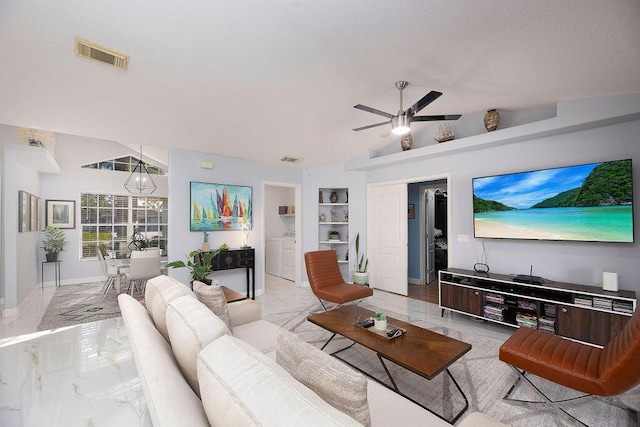 living room featuring washer and clothes dryer, built in shelves, vaulted ceiling, and ceiling fan