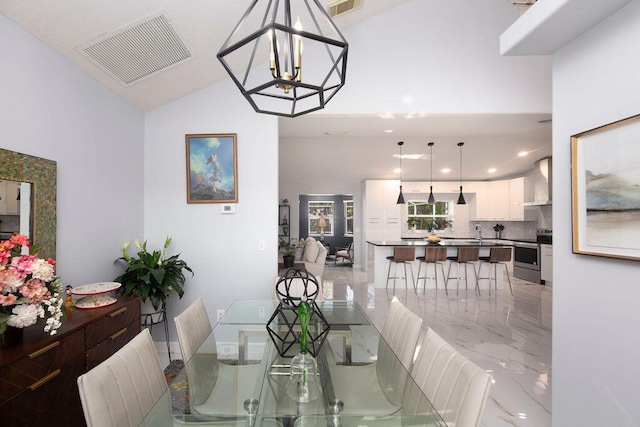 dining room featuring vaulted ceiling, sink, and an inviting chandelier