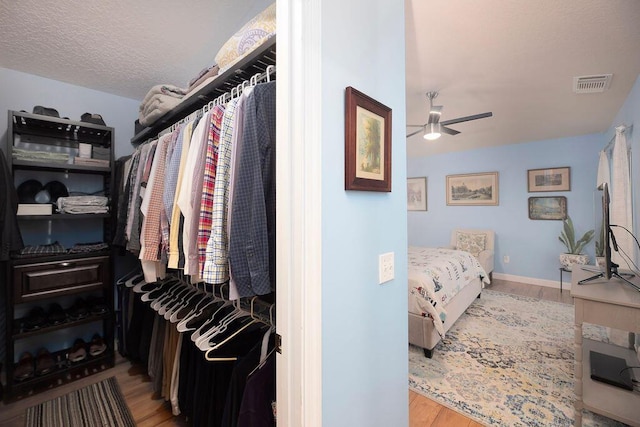 spacious closet featuring light hardwood / wood-style floors and ceiling fan