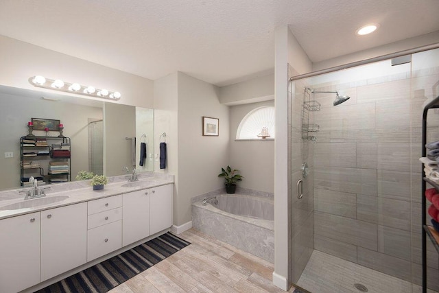 bathroom featuring vanity, plus walk in shower, and hardwood / wood-style floors