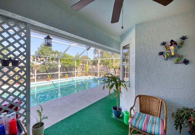 view of swimming pool with ceiling fan and glass enclosure