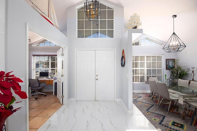 entryway featuring high vaulted ceiling and a chandelier