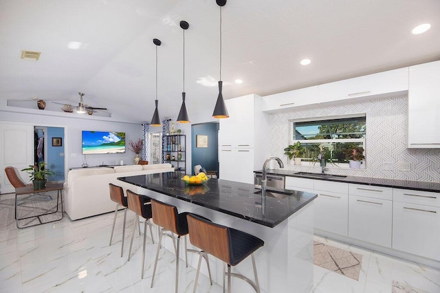 kitchen with white cabinetry, backsplash, pendant lighting, and sink