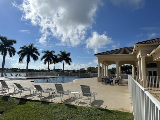 view of pool featuring a water view and a patio