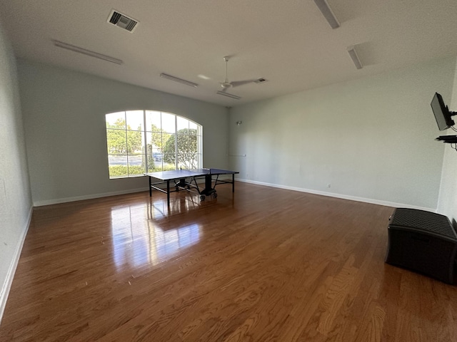 recreation room with ceiling fan and dark hardwood / wood-style flooring