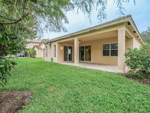 back of house with a yard and a patio area