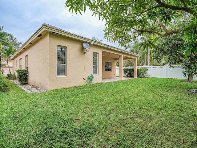 back of house featuring a yard and a patio