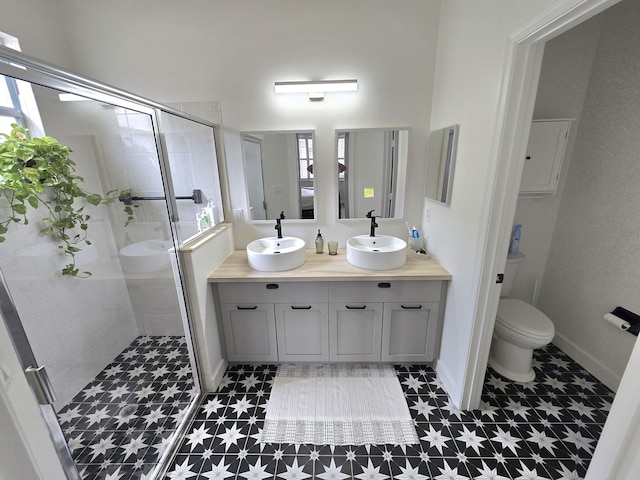 6001 Spring Lake Ter, Fort Pierce, FL 34951 - full bathroom featuring a stall shower, double vanity, toilet, tile patterned floors, and baseboards