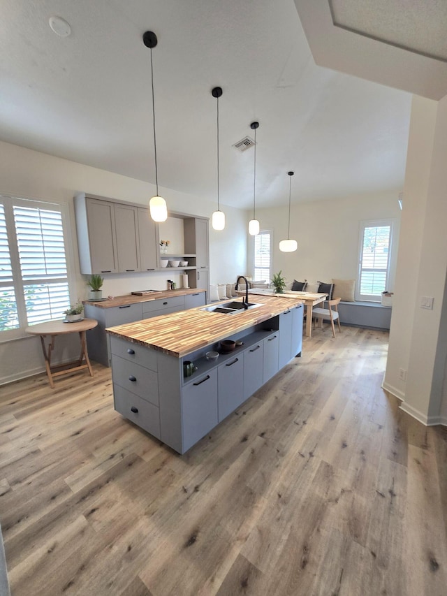 6001 Spring Lake Ter, Fort Pierce, FL 34951 - kitchen featuring butcher block counters, plenty of natural light, light wood finished floors, and a sink