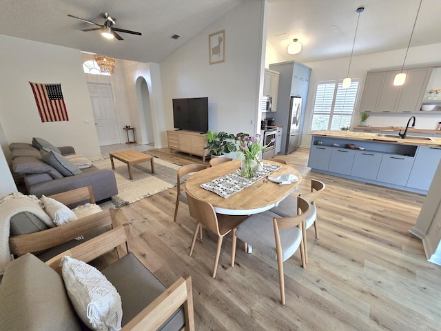 6001 Spring Lake Ter, Fort Pierce, FL 34951 - living area featuring arched walkways, ceiling fan, light wood-style flooring, and high vaulted ceiling