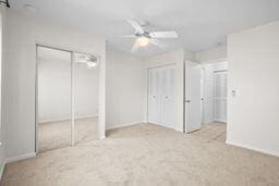 unfurnished bedroom with ceiling fan and light carpet