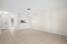 empty room with ceiling fan and light tile patterned floors