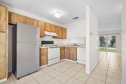 kitchen with white appliances and light tile patterned floors