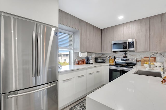 kitchen with appliances with stainless steel finishes, tasteful backsplash, and sink