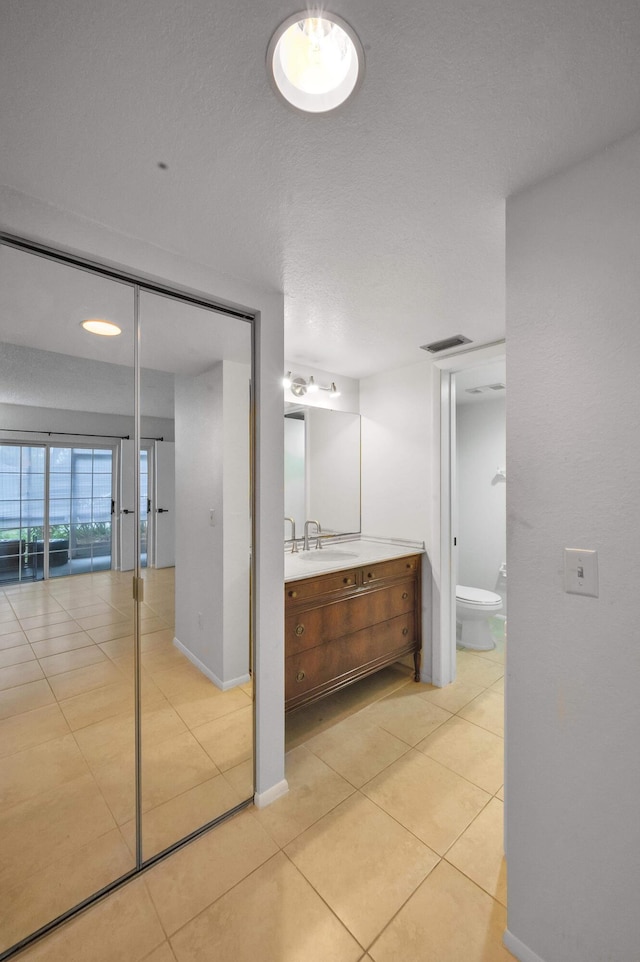 bathroom featuring tile patterned flooring, vanity, and toilet