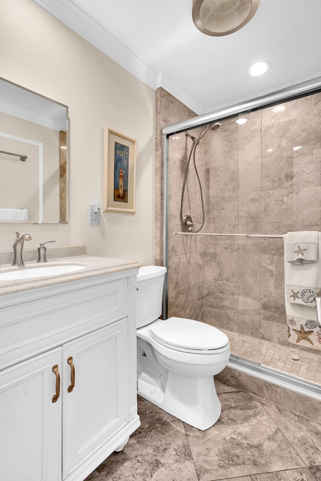 bathroom featuring vanity, toilet, ornamental molding, and a shower with door