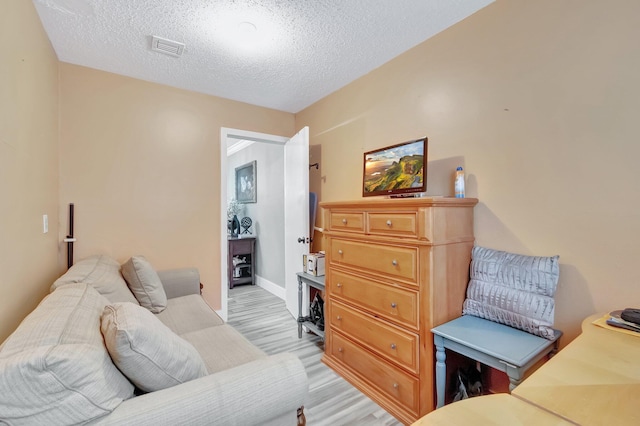 interior space featuring a textured ceiling and light hardwood / wood-style floors