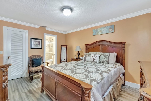 bedroom featuring a textured ceiling, light wood-type flooring, ensuite bath, and ornamental molding