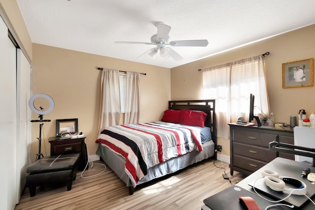 bedroom with light wood-type flooring, a closet, and ceiling fan