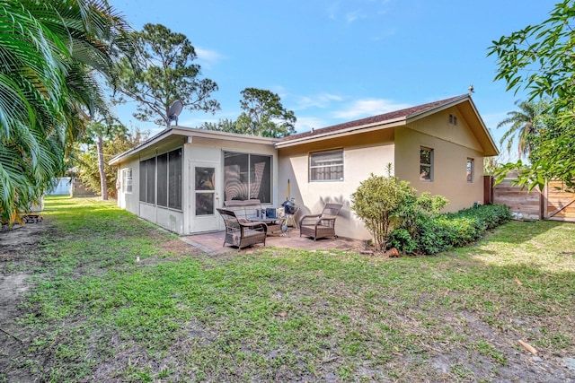 back of house featuring a lawn, a patio area, and a sunroom