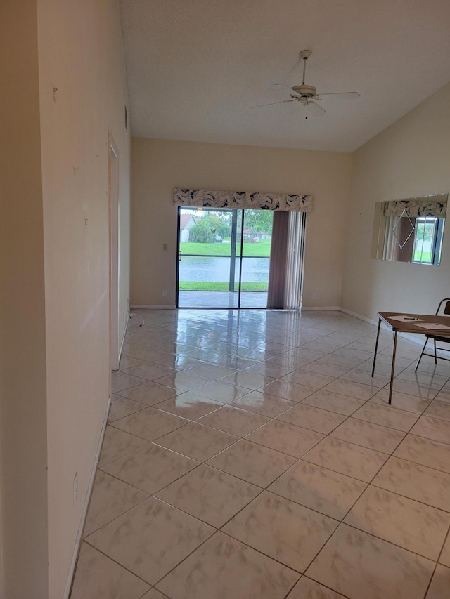 tiled spare room with ceiling fan, a wealth of natural light, and lofted ceiling