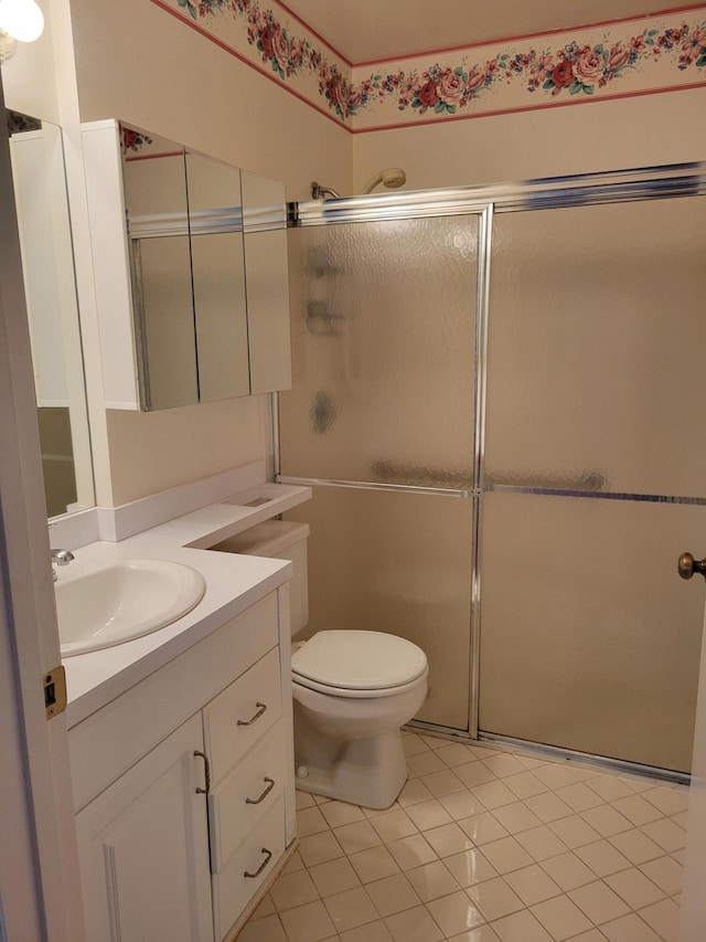 bathroom with toilet, tile patterned floors, an enclosed shower, and vanity