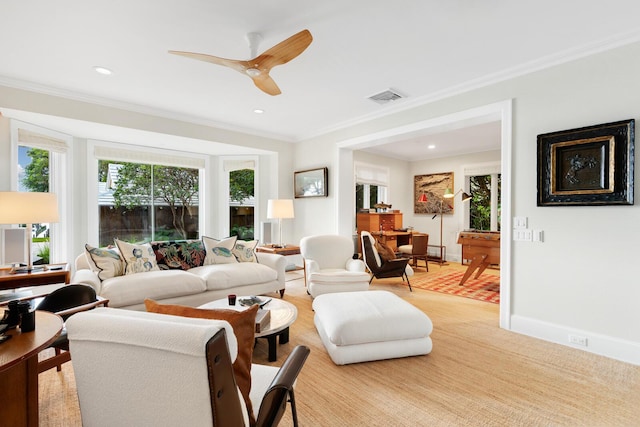 carpeted living room featuring ornamental molding and ceiling fan