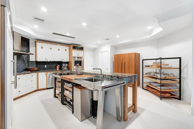 kitchen featuring dishwasher, white cabinets, wall chimney range hood, sink, and tasteful backsplash