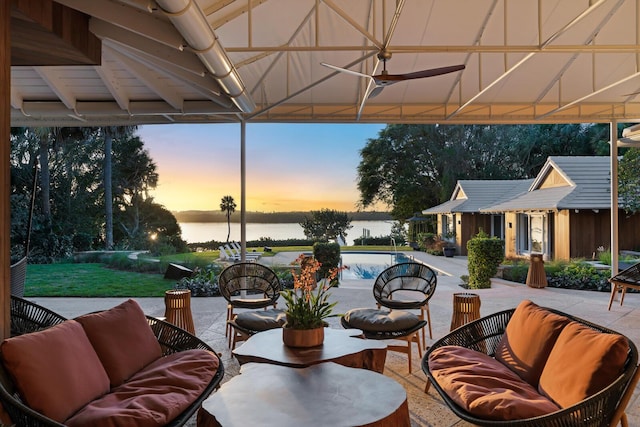 patio terrace at dusk featuring a gazebo, a water view, an outdoor hangout area, and ceiling fan